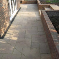 Concrete slabed patio with brick wall and steps